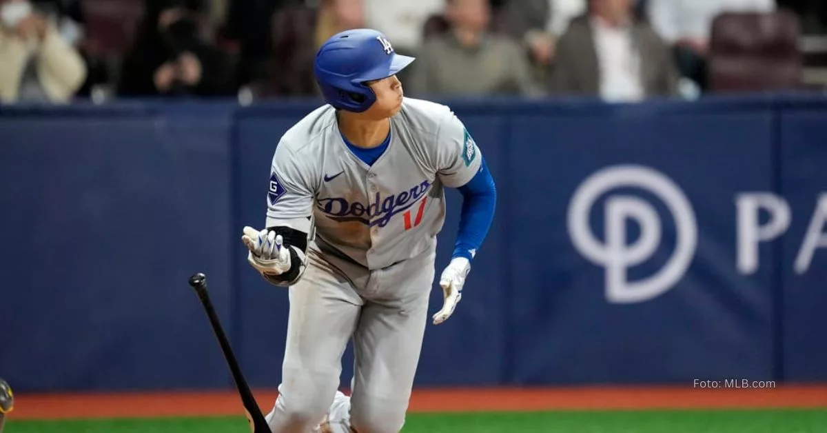 Shohei Ohtani iniciando la carrera de home a primera mientras observa la bola con el uniforme de Los Angeles Dodgers